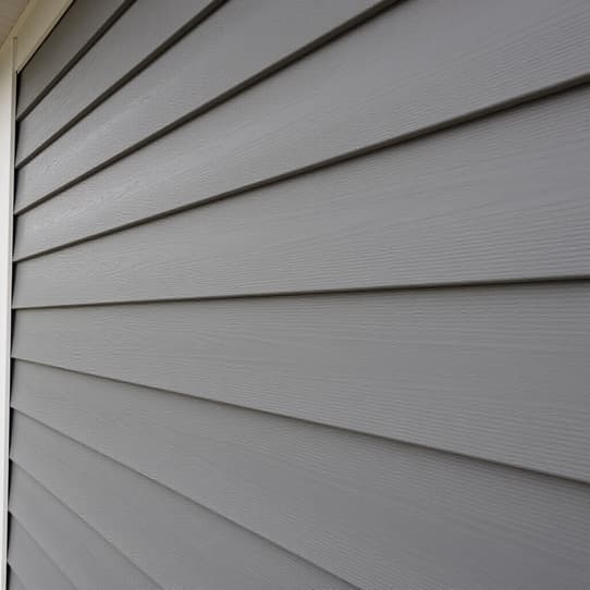 Close-up of new James Hardie fiber cement lap siding installation on a San Antonio home exterior